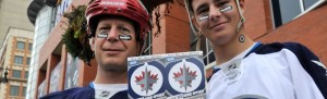 Photo unceremoniously borrowed from the Winnipeg Sun: Winnipeg Jets fans Nelson (right) and Doug Quara show off their tickets before the NHL Winnipeg Jets inaugural game against the Montreal Canadiens in Winnipeg, October 9, 2011. REUTERS/Fred Greenslade