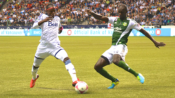 Whitecaps FC striker Darren Mattocks attempts to poke the ball past Portland Timbers defender Pa Modou Kah during MLS action on 9 October 2013. Photo by Jason Kurylo for Pucked in the Head.