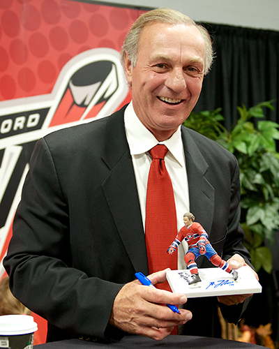 Hockey Hall of Famer Guy Lafleur poses with his Spawn Toys likeness during the Abbotsford Heat home opener Friday night. Photo by Jason Kurylo for Pucked in the Head.