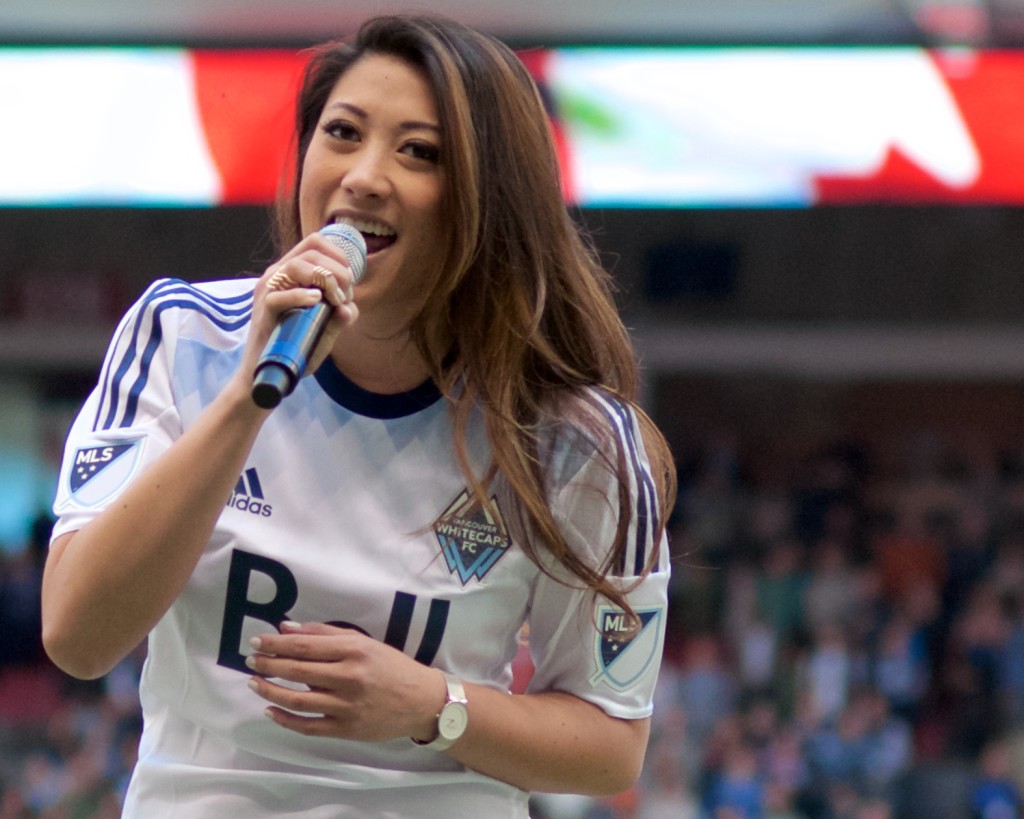 Marie Hui sings the national anthem prior to the Vancouver Whitecaps season opener. Sadly, the home team lost their 2015 home opener to the dirty, rotten, stinkin' doughbugs of TFC 3-1. Photo by Jason Kurylo for Pucked in the Head.